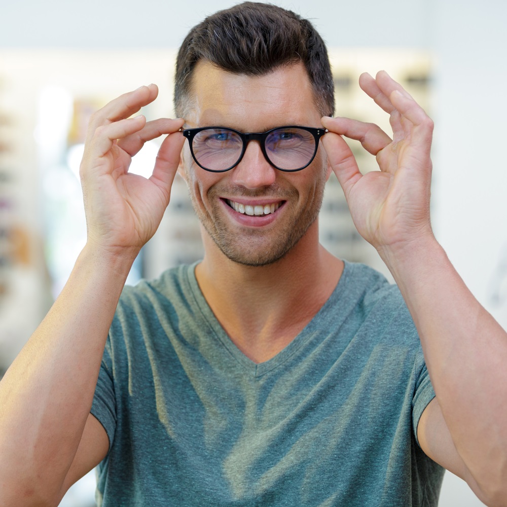 smiling man wearing eyeglasses in optical shop