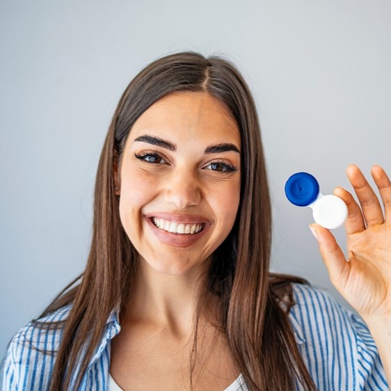 Woman holding plastic container with contact lenses